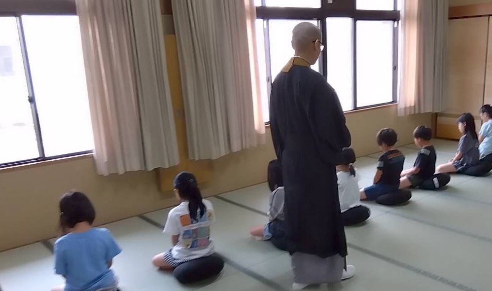 姿勢と呼吸の案内を受けながら座る参加者